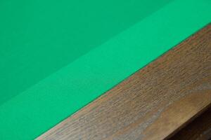 A Green Felt Pool Table Surface Featuring a Beautiful Wooden Edge for Enhanced Aesthetics photo