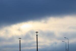 A Stunning Cloudy Sky With Street Lights Beautifully Depicted in Silhouette Form photo