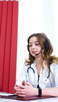 Female doctor or family therapist using online chat to talk with patient and check possible symptoms during pandemic of coronavirus. Health concept. Vertical video
