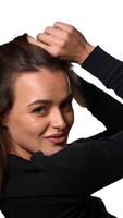Woman with hairstyle trembling from laugh. Smiling positively and being in great mood while standing over white background. Vertical video