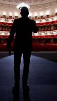 Actor walks on a scene in front of empty auditorium. Financial losses of organizers in entertainment sector because of quarantine. Vertical video