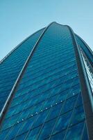 The Stunning Reflection of a Modern Skyscraper in the Vibrant Urban Environment Around It photo