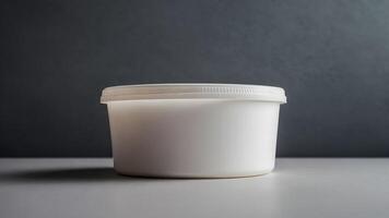 A white container with a lid on a table photo