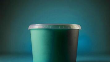 A green plastic container with a lid on a blue background photo