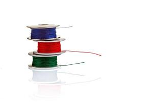 spools of thread in blue, red, green colors on a white background photo