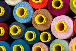 set of multi-colored spools of thread for sewing photo