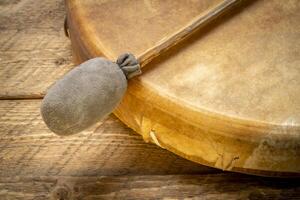 handmade, native American style, shaman frame drum covered by goat skin with a beater or a rustic wood photo