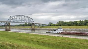 Towboat with barges is passing under a bridge on the Chain of Rocks Canal of MIssissippi River above St Louis photo
