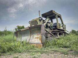 old abandoned military bulldozer overgrown by vegetation photo