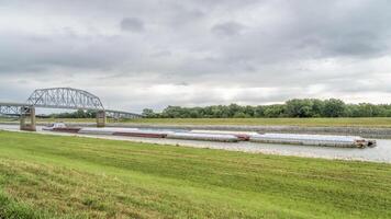 Towboat with barges is passing under a bridge on the Chain of Rocks Canal of MIssissippi River above St Louis photo