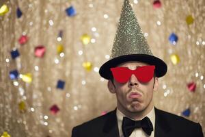 A man wearing a party hat and sunglasses photo