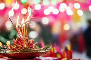 A colorful bowl with incense sticks on it photo