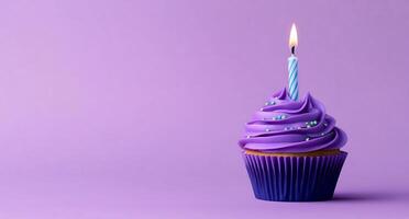 A cupcake with a single candle on a purple background photo