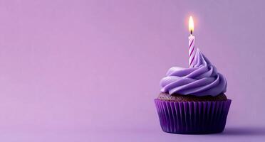 A purple cupcake with a single candle on top photo