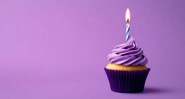 A purple cupcake with a single candle on top photo