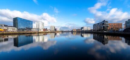A river with buildings and clouds reflected in it photo