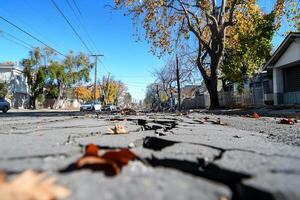 A street with a crack in it and leaves on it photo