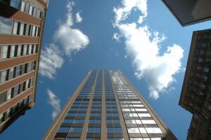 A tall building reaching towards a blue sky with scattered clouds. photo