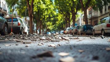 A street scene with trees, parked cars, and debris on the ground. photo