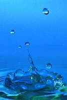 High-speed photograph of a water drop impacting on water showing secondary drops formation photo