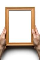 Two hands grasp a wooden frame, positioning it for an empty space ready for artwork or photos