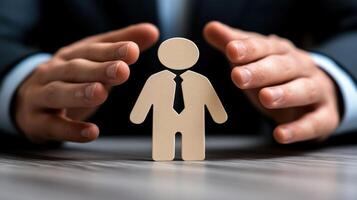 A businessman gestures protectively around a wooden figure, representing support during a corporate discussion photo