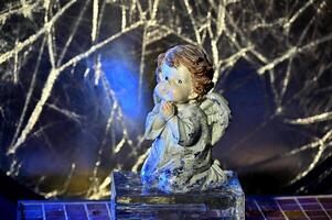 a figurine of an angel sitting on a block photo
