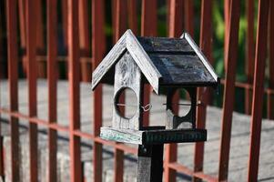 a birdhouse is shown in front of a fence photo