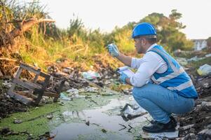 Water resource experts check the water quality in a community canal contaminated with garbage in the canal. photo