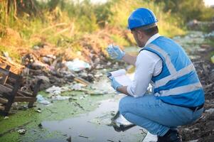 Water resource experts check the water quality in a community canal contaminated with garbage in the canal. photo