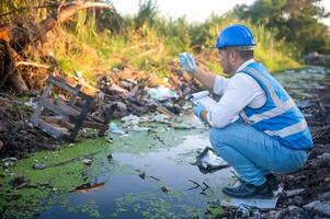 Water resource experts check the water quality in a community canal contaminated with garbage in the canal. photo