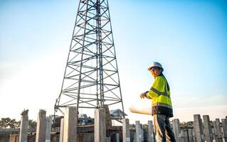 A female engineer is standing and inspecting the progress of the pillar installation for the construction of a building. photo