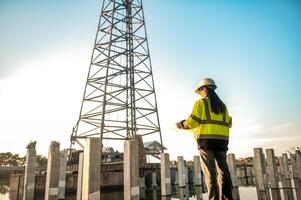 A female engineer is standing and inspecting the progress of the pillar installation for the construction of a building. photo