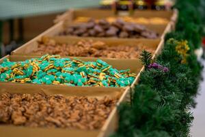 View of a counter with various types of cookies decorated with fir branches photo