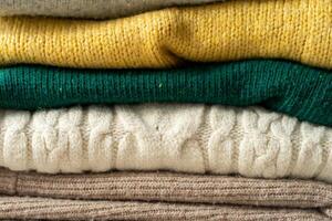 A stack of knitted sweaters on the table. Background textures photo