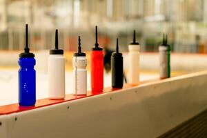 View of many different water bottles standing on the side of the ice arena photo