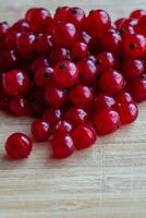 macro photography of red currant berries on a wooden table photo