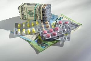Jelly capsules and hard tablets of vitamin D on dollar bills on a white table photo