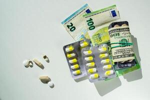 Jelly capsules and hard tablets of vitamin D on dollar bills on a white table photo
