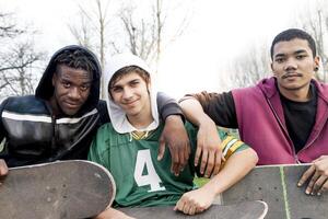 group of young adults sitting on a ramp with skateboard photo