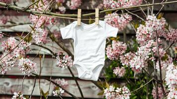 A white baby bodysuit hanging from a clothesline photo