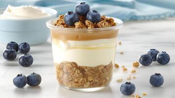 A glass of yogurt with blueberries and granola photo