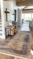 A large rug in a foyer with wooden floors photo