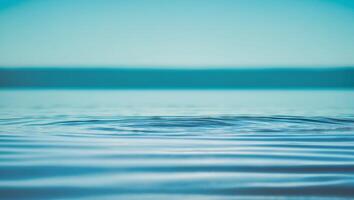 A wave is seen in the water with a blue sky photo
