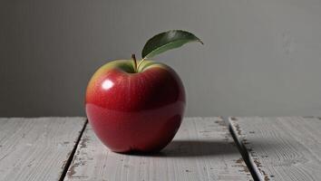 A red apple sitting on a wooden table photo