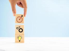 Business plan and strategy concept. Close-up of hand arranging wooden blocks with icon business strategy photo