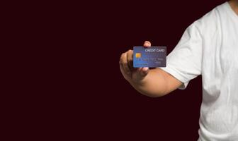 Close-up of hand holding a mockup credit card while standing on a red background photo