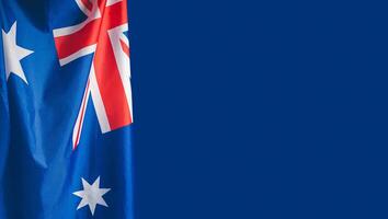 Close-up of the Australian flag is on the left side on a blue background photo