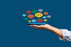 Close-up of hands using mobile phone with colorful chat icons on the application photo
