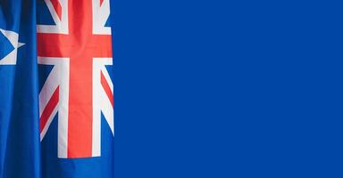 Close-up of the Australian flag is on the left side on a blue background. photo